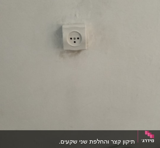 שקע חשמל על קיר לבן עם סימני לכלוך